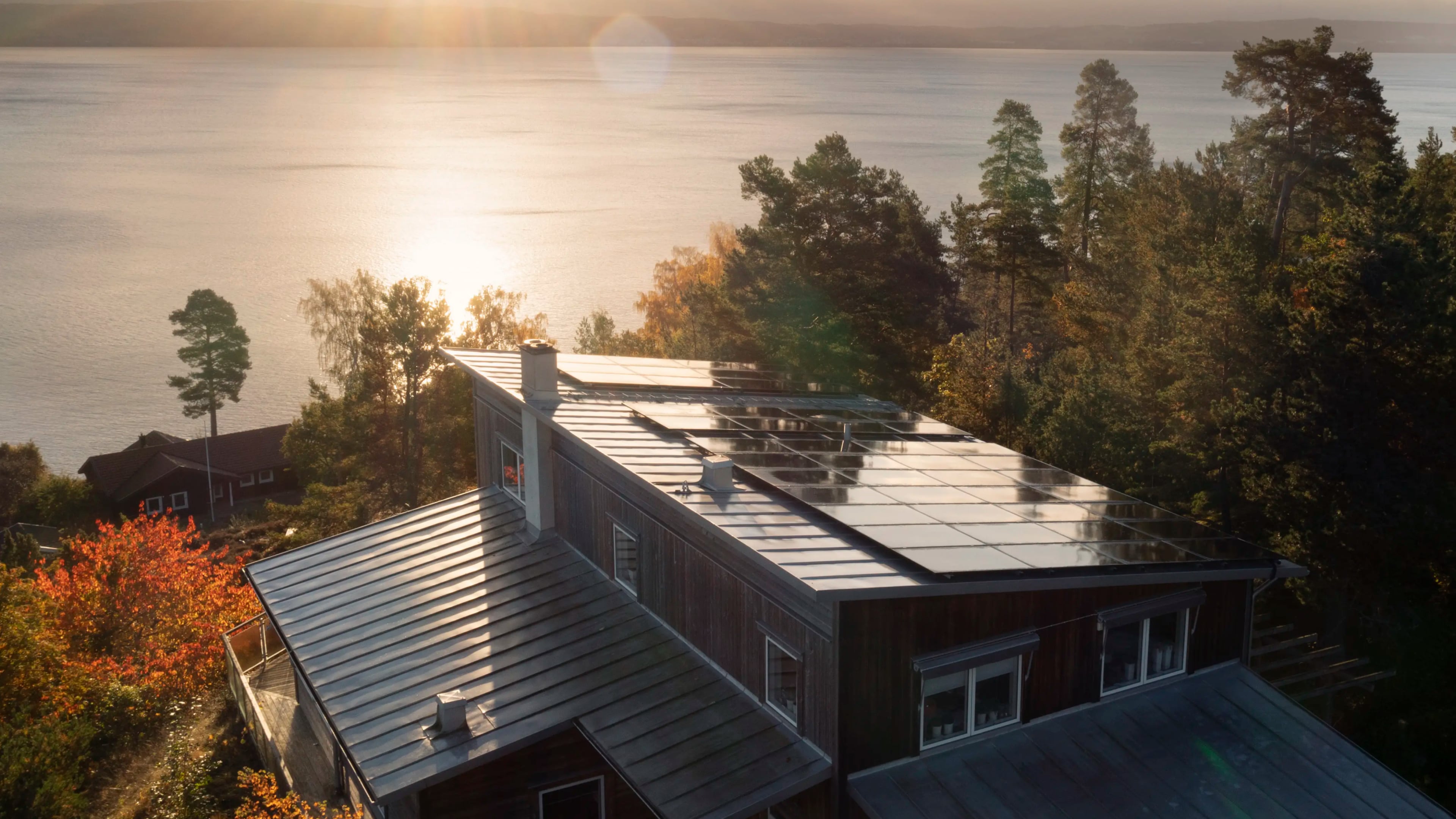 Drönarvy över solcellsanläggning i solnedgång